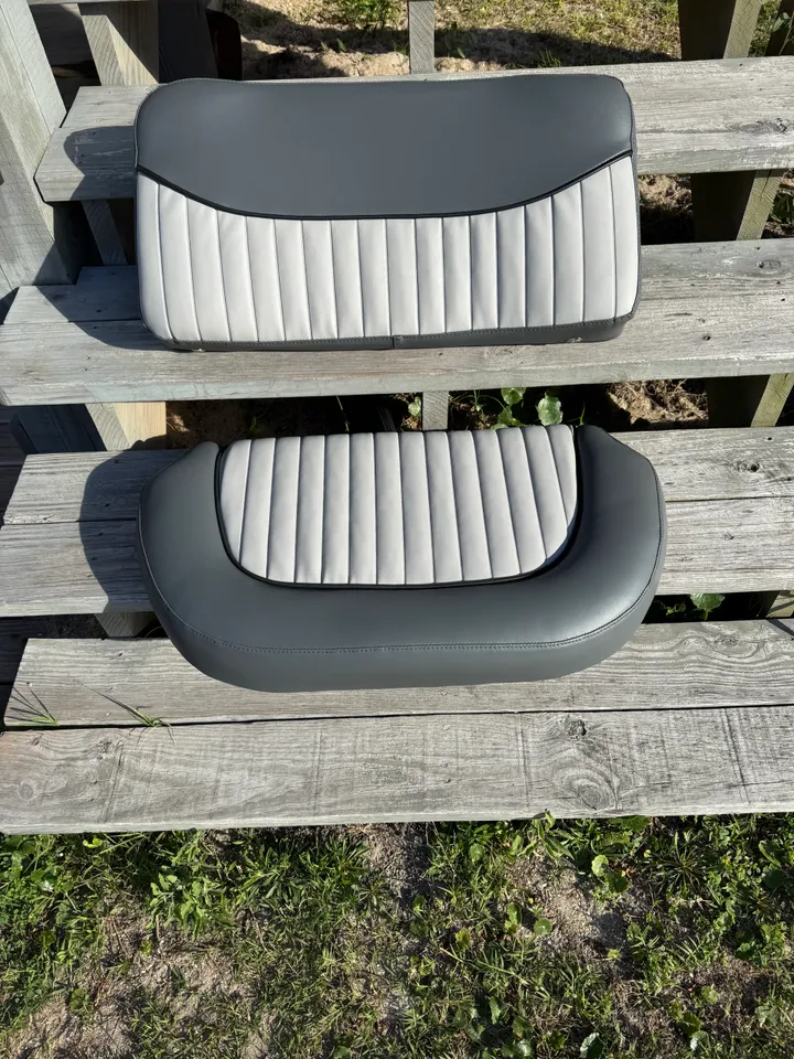 Charcoal and light gray two-tone channel-stitch boat seat set on wooden fence