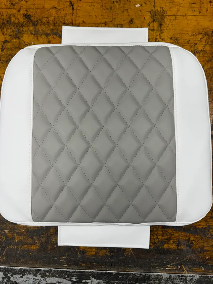 White and gray diamond-quilted boat cushion top view on workbench