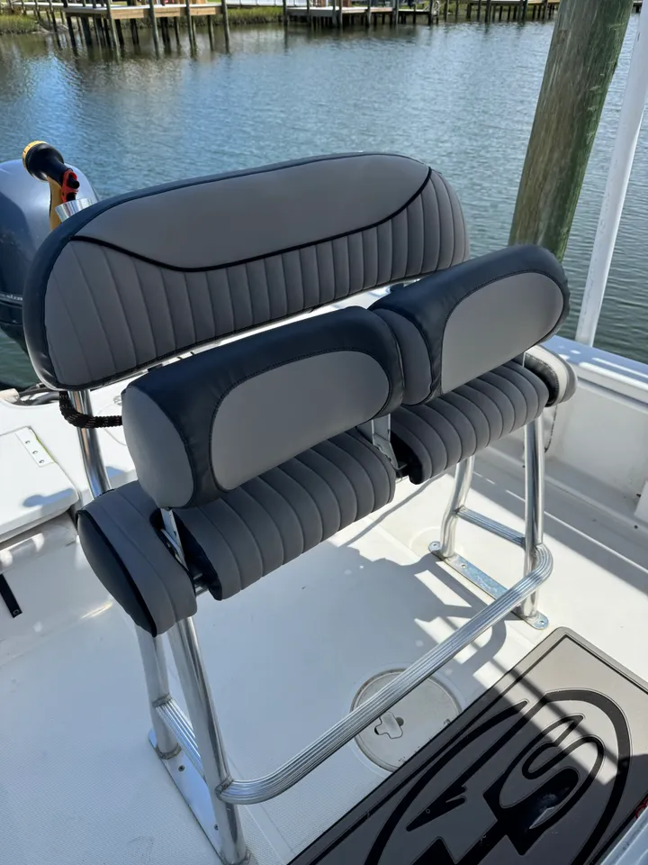 Gray and charcoal marine seat with vertical channel stitching on boat at marina